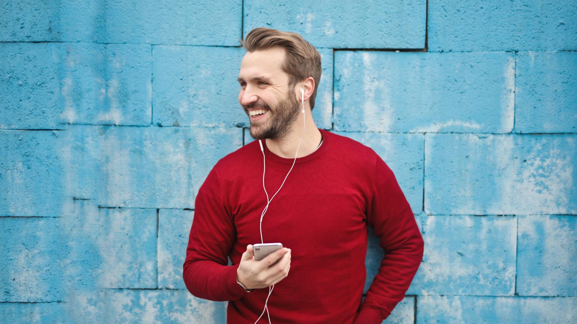 Middle-aged man holding his phone smiling