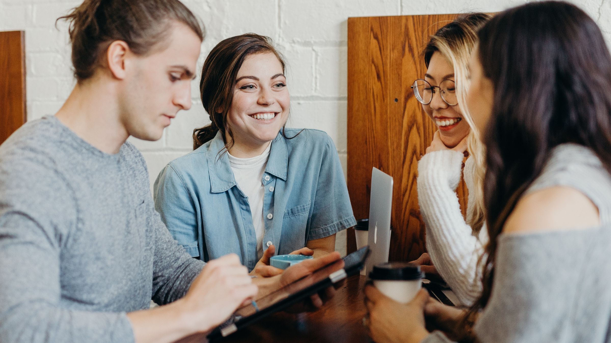 Group of people sitting smiling around a table.